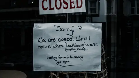 A shop window in Darlington, England displays a closed sign due to lockdown.
