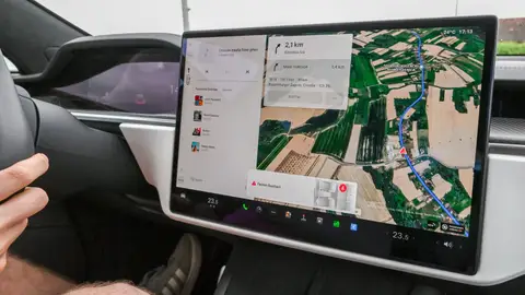 Inside view of a car with a large navigation screen and detailed digital map.