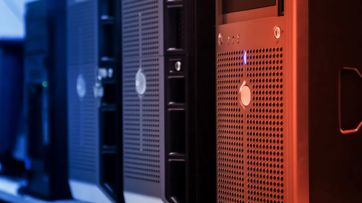 Close-up of tower servers in a data center with blue and red lighting.