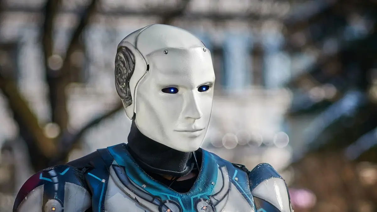 Close-up of a futuristic humanoid robot with metallic armor and blue LED eyes.