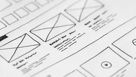 Detailed close-up of a hand-drawn wireframe design on paper for a UX project.