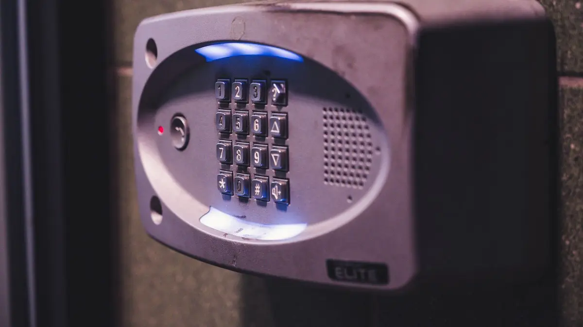 A close-up image of an illuminated security keypad mounted on a wall.