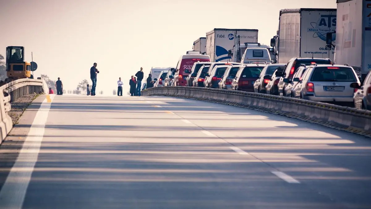 A congested highway with cars and trucks in a traffic jam during daylight.