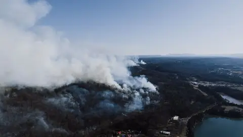 Drone view of a forest wildfire near Rossville, Georgia, USA, smoke rising.