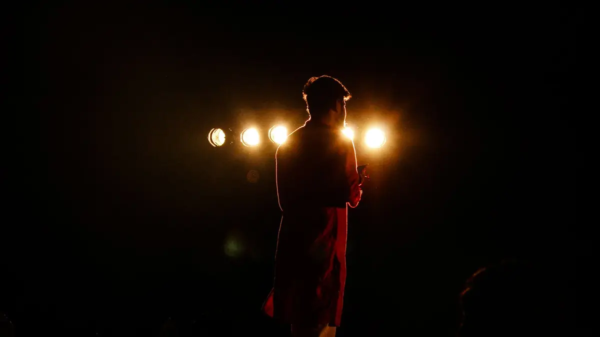 Captivating silhouette of a performer on stage with dramatic lighting and backlight.