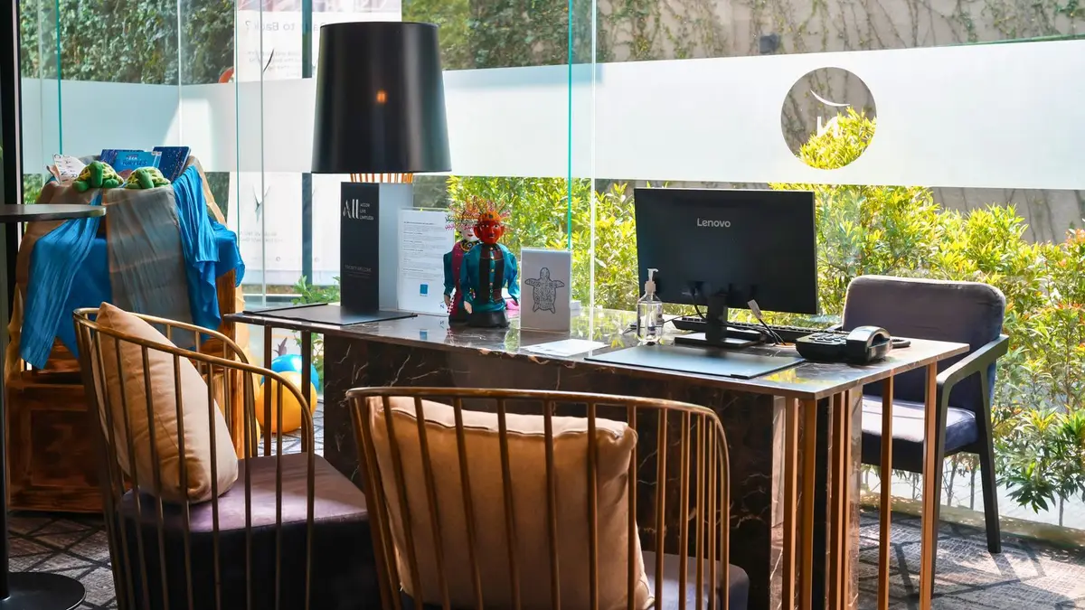 Stylish hotel reception area featuring modern design and computer setup in Jakarta, Indonesia.