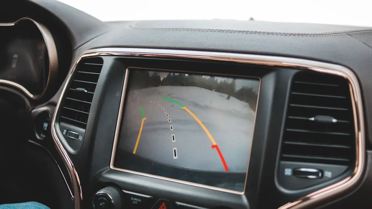 Close-up of a car's dashboard showing a rearview camera display for parking assistance.