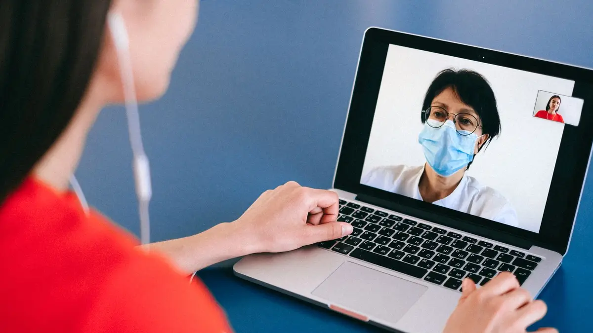 Doctor and patient on a video call for telehealth consultation during COVID-19 era.