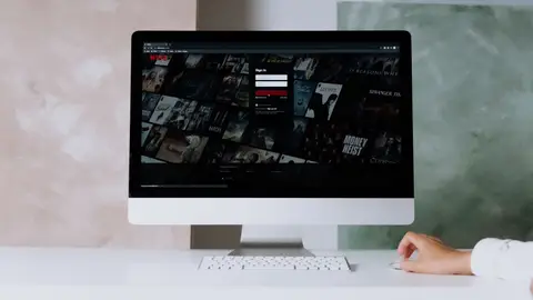 A modern desktop displays a streaming service interface, showcasing entertainment options in a minimalist office setting.