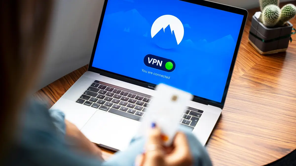 A person using a VPN on a laptop, symbolizing secure internet browsing in a modern indoor setting.