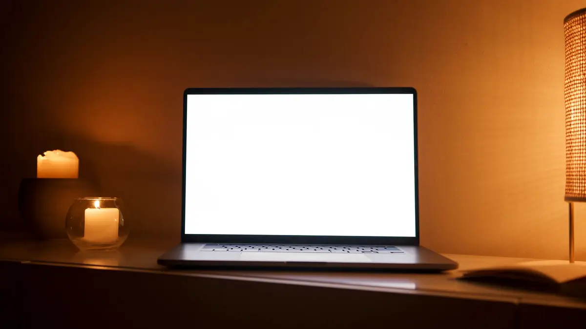 A warm-toned workspace with a laptop and lit candles, perfect for relaxation or work.