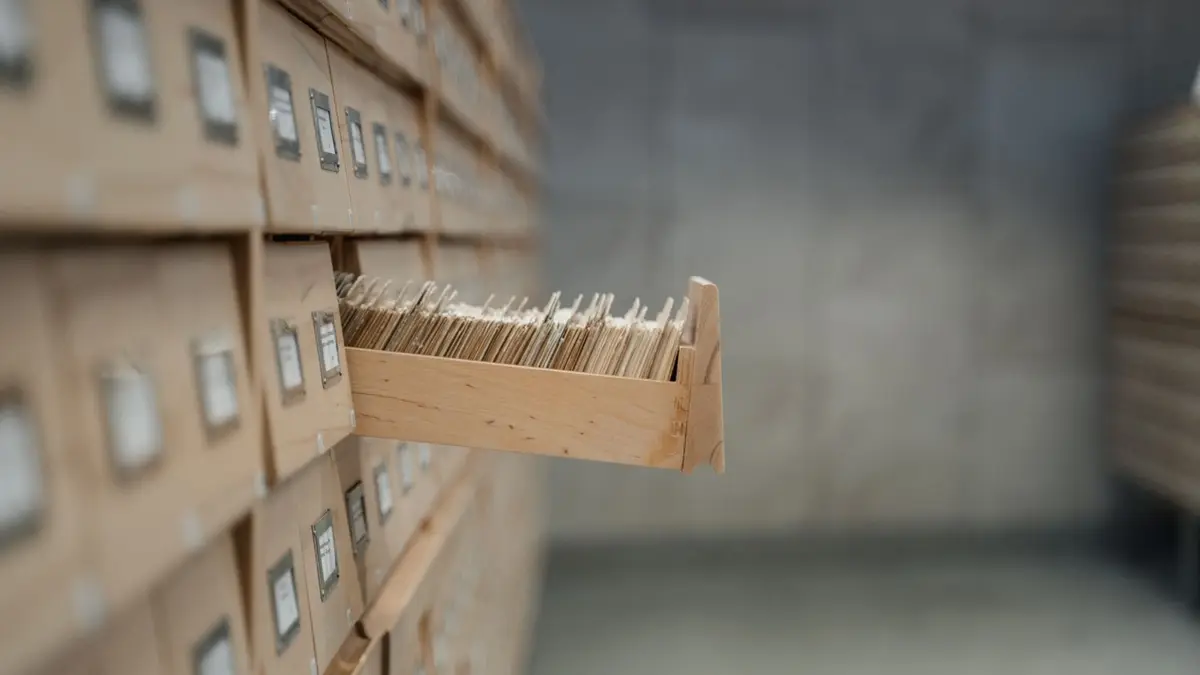 A vintage card catalog drawer in an archive library setting, highlighting organization and history.