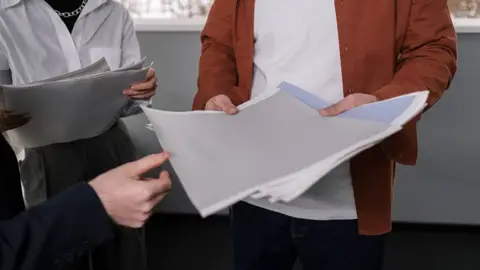 Business professionals discussing interior design samples during a project meeting.