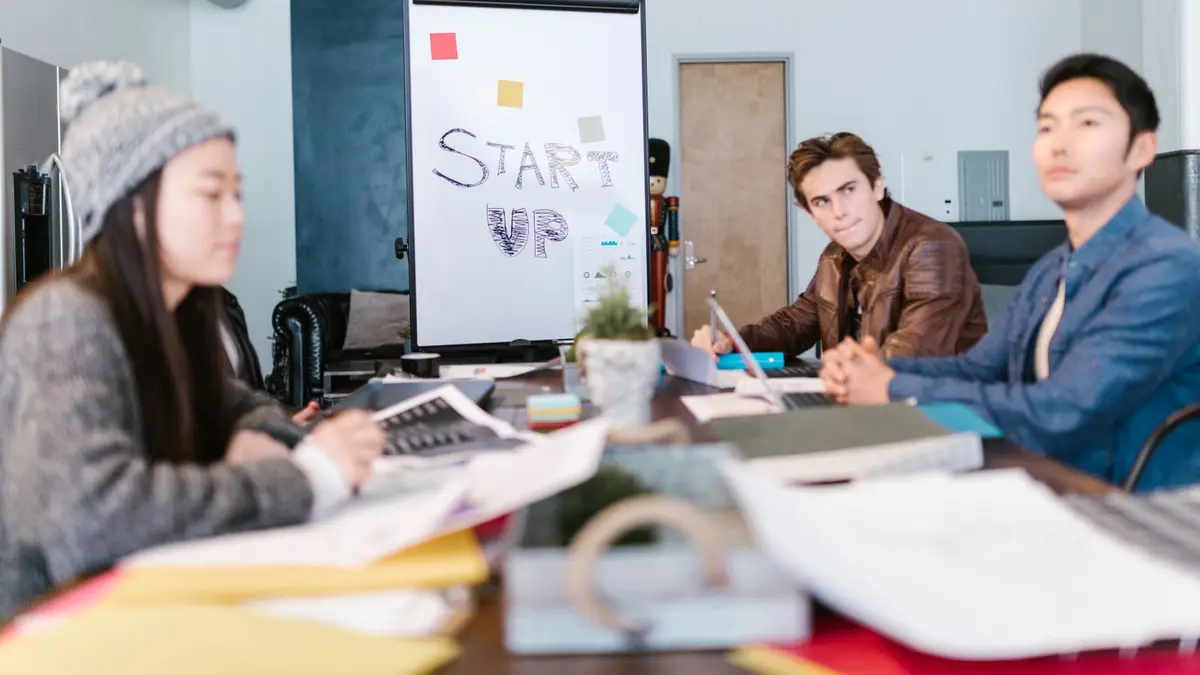 A group of young professionals brainstorming ideas in a startup office setting.