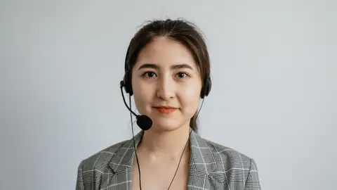 Portrait of a young female call center agent in a professional setting wearing a headset.