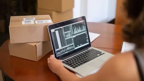 Small business owner managing online orders from a laptop in Portugal.