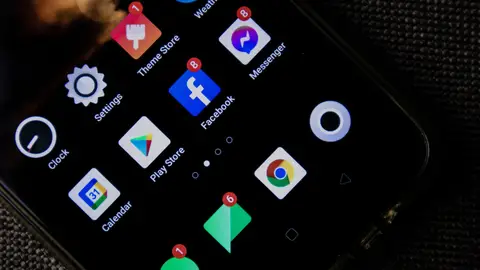 Close-up of a smartphone screen displaying various social media and app icons.