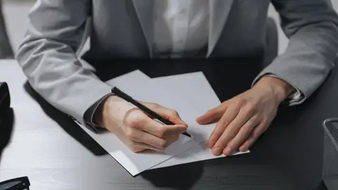 Professional hands signing a document in an office setting for business purposes.